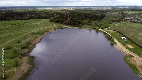 Aerial: Country landscape and flying over a lake in the nearest suburb. 
New Moscow area near Kamenka village, Russia.
Color graded.
