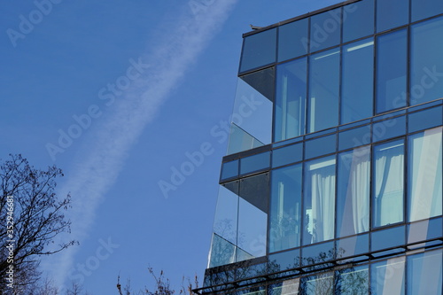 blue glass facade of modern office or public building made of identical triangular elements. Metal supporting structures are visible through the glass. modern architecture, high-grade glass structures
