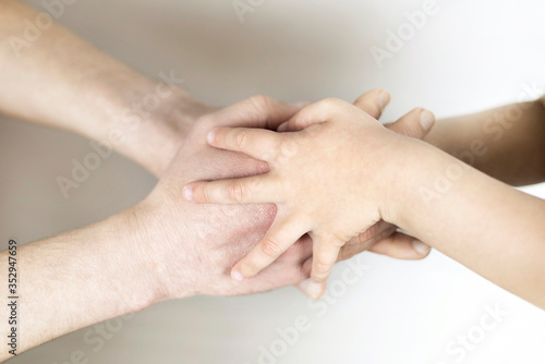 The concept of support and assistance, the hands of a little boy hold the hands of an adult. Top view