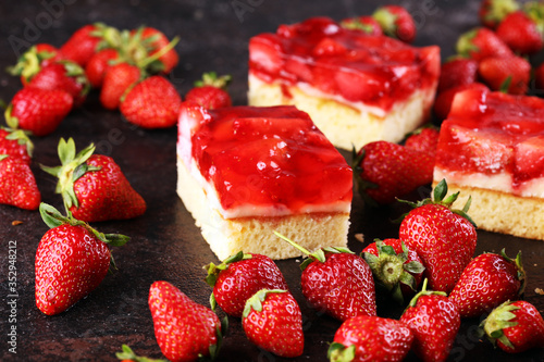 strawberry cake and many fresh strawberries on rustic background table