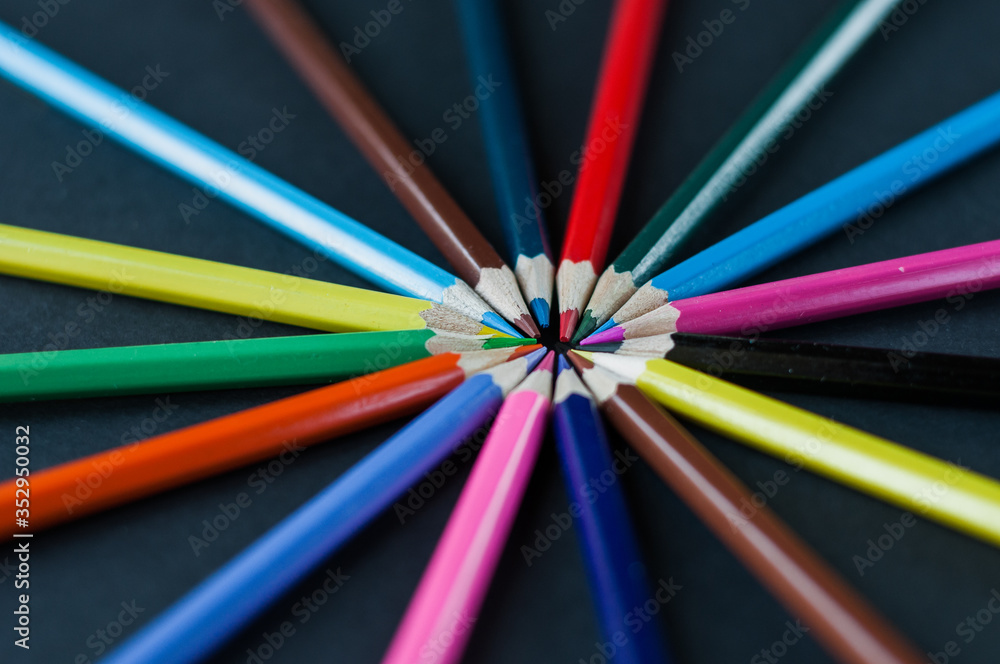 Circle of colour pencils on black background.Close up. Many different colored pencils on dark purple background.Colorful pencil. Circle of colour pencils on black background.Close up. Many different colored pencils on dark purple background.Colorful pencil.