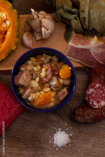 Locro, cocina argentina, un guiso muy popular hecho con calabaza, frijoles, maíz blanco, carne, salchichas, etc. Sobre una tabla de madera photo