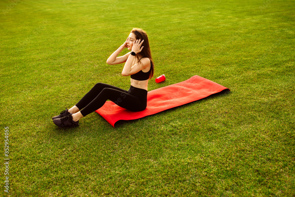 Happy sporty woman resting after training on the stadium Happy sporty woman resting after training on the stadium