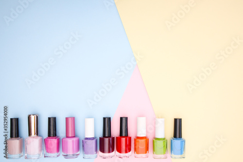 Nail accessories, nail polishes on colorful background 