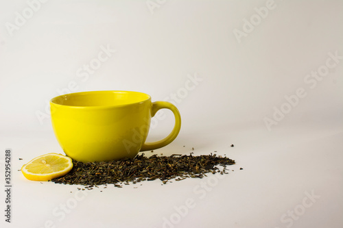 yellow cup with delicious tea and lemon (lime)