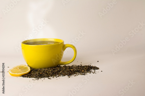 yellow cup with delicious tea and lemon (lime)