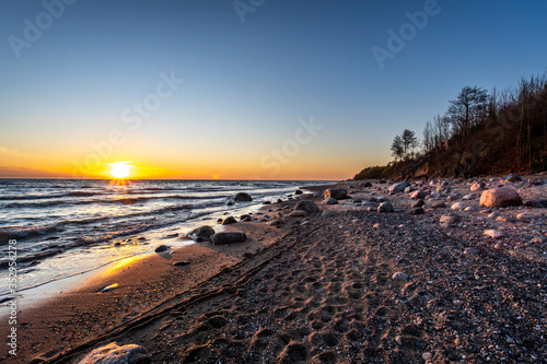 Fototapeta Naklejka Na Ścianę i Meble -  Beautiful romantic sunset at empty Karkle beach with many stones, Klaipeda/ Lithuania
