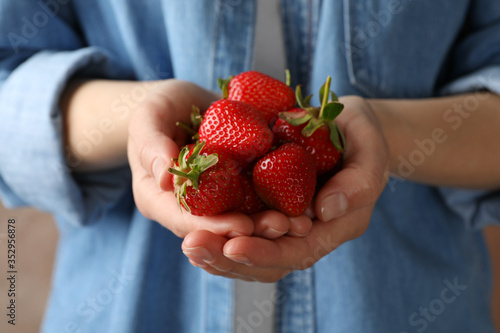 Woman holds bowl with tasty strawberry, close up. Summer berry