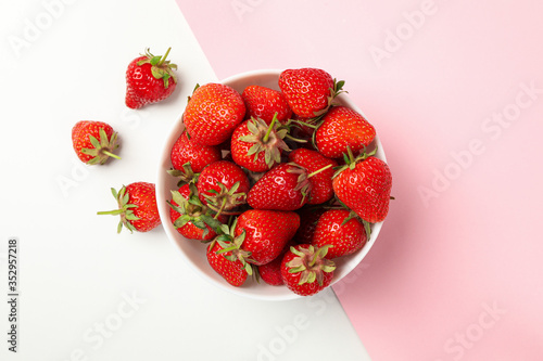 Bowl with tasty strawberry on two tone background. Summer berry
