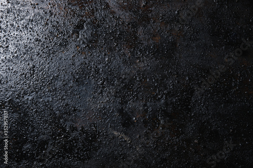 Black isolated textured background photographed with studio light.