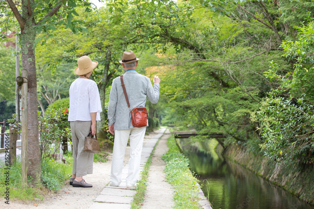 Senior couple walking along riverside footpath Senior couple walking along riverside footpath