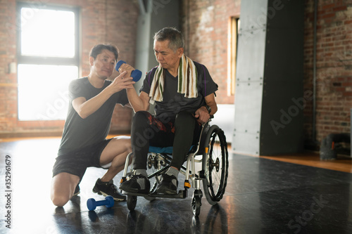 Senior man undergoing rehabilitation with trainer