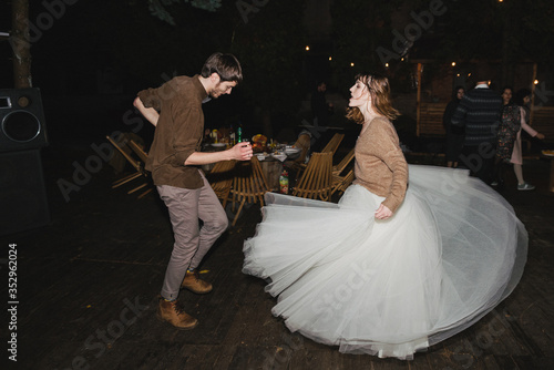 Romantic and happy caucasian couple in casual wedding clothes dancing at the night party. Love, relationships, romance, happiness, urban concept. Man and woman celebrate their marriage.