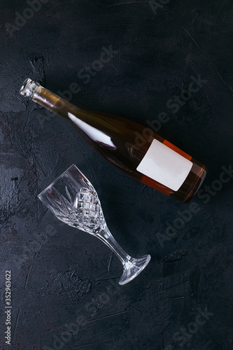 Obraz na płótnie Bottle of rose wine with a glass on black textured isolated background photographed with studio light. w salonie