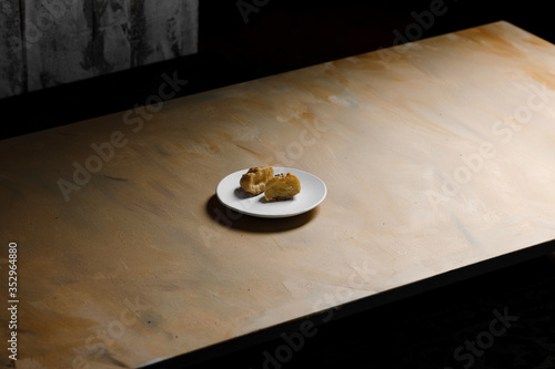 Obraz na płótnie Delicious profiteroles on white mate dish and yellow isolated background. w salonie