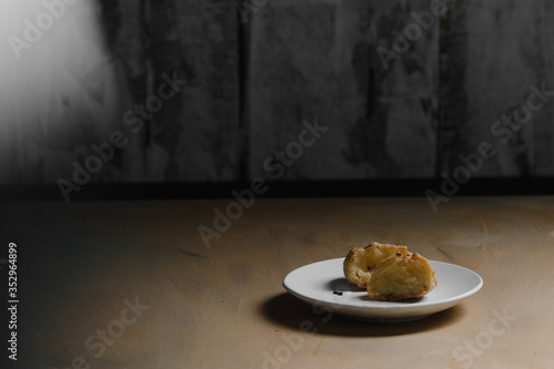 Obraz na płótnie Delicious profiteroles on white mate dish and yellow isolated background. w salonie