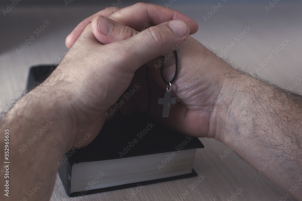 men's hands lie on the bible