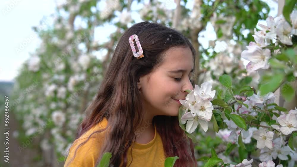 Portrait of teenage girl smelling white apple tree flowers Portrait of teenage girl smelling white apple tree flowers