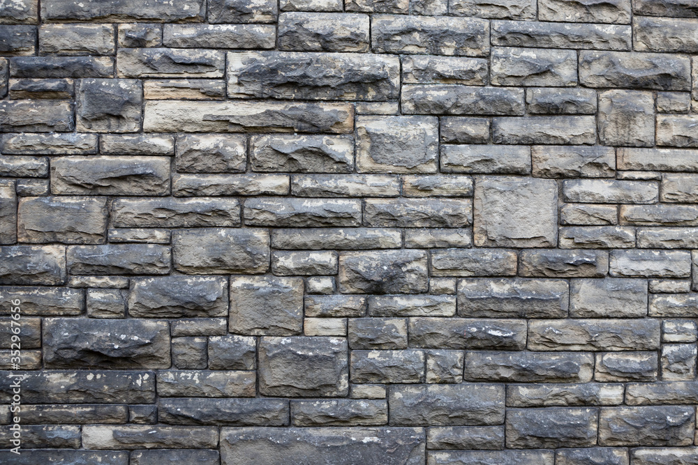 Obraz premium Textured stone wall background. Square patterns and rough texture