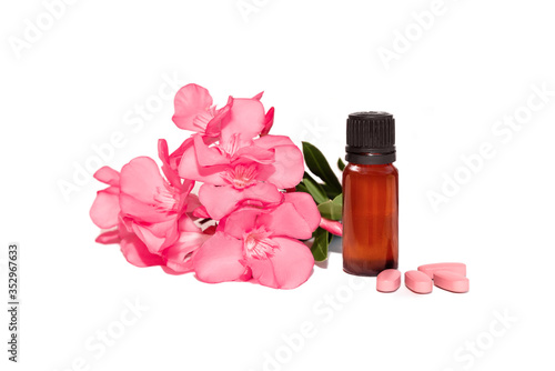 photo of cosmetic bottle with oil and pink pills and flowers isolated, on a white background. herbal vitamins