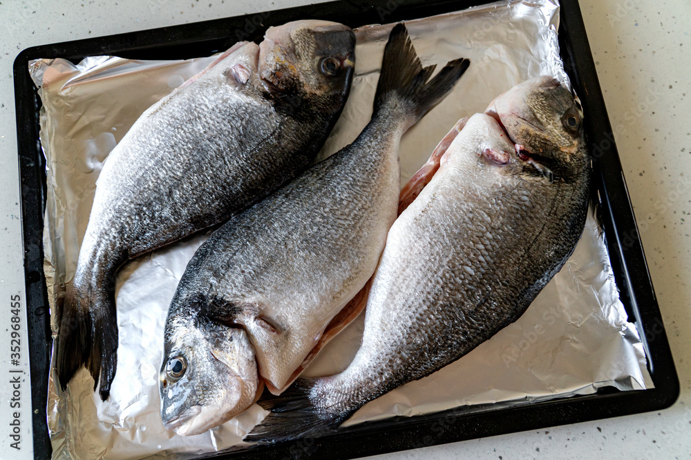 Raw Dorada Fish on a Baking Tray. Cooking fish at home