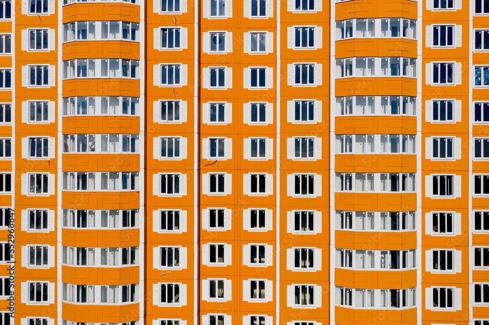 Tall residential apartment building with many windows and balconies. Aerial view.