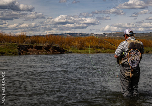 A man fly fishing on a western trout stream in the spring. photo