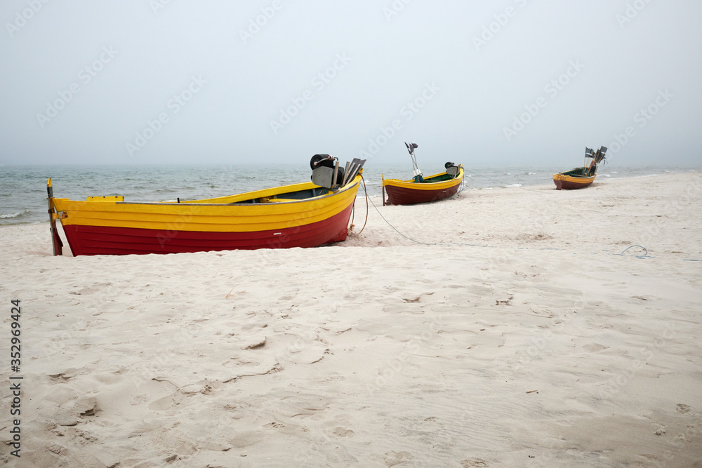 Fishing boats on the beach on a cloudy and foggy day. Baltic Sea, Poland