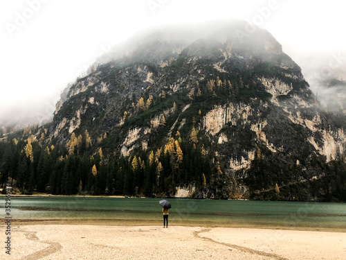 man walking on a mountain lake