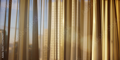 sunlight through transparent curtain on window of home or office in evening