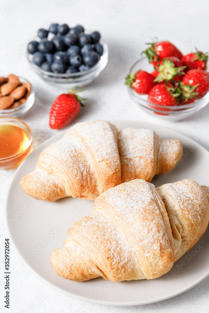 Breakfast with fresh croissants and berries on white table background Breakfast with fresh croissants and berries on white table background