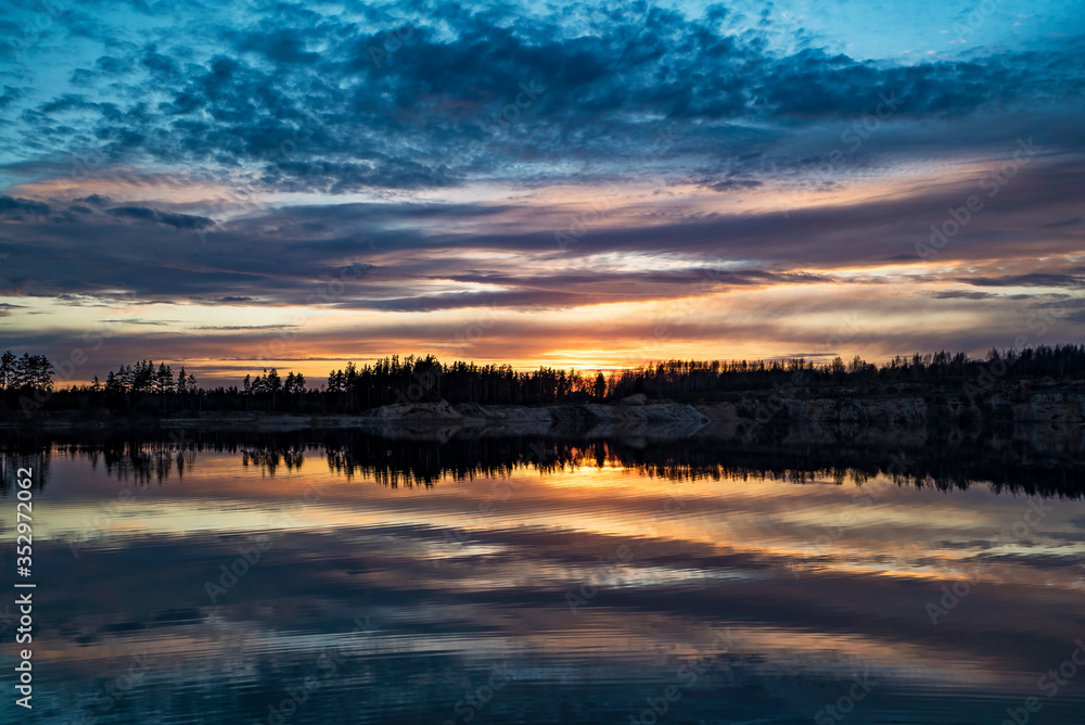 Mirror image of the sunset on the lake in spring.