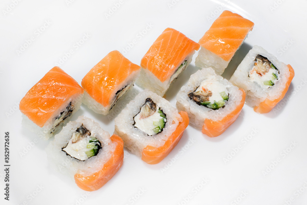 Japanese traditional roll of rice, salmon, cream cheese, cucumber and eel on a white background Japanese traditional roll of rice, salmon, cream cheese, cucumber and eel on a white background