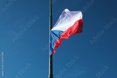 A lowered Czech flag flutters in the wind.