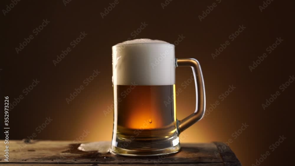 A Glass Of foamy Beer On A Wooden Table, Dark orange Background A Glass Of foamy Beer On A Wooden Table, Dark orange Background