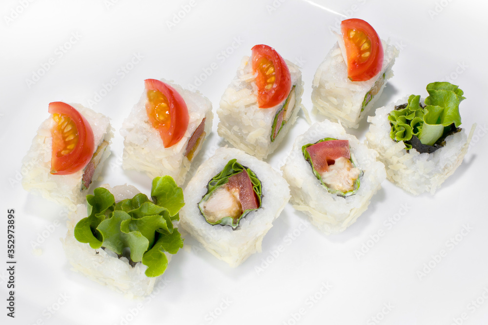 Japanese Caesar roll made from rice, cherry tomato, chicken, lettuce, Parmesan cheese and Caesar sauce on a white plate