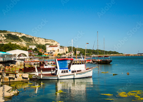 NESSEBAR, BULGARIA - SEPTEMBER 27, 2016: Fishing boats berthed in the marina of Old Town at sunset. Nessebar is an ancient town and one of the major seaside resorts on the Bulgarian Black Sea Coast.