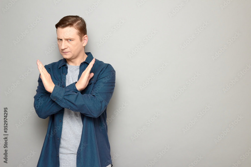 Portrait of serious man making cross with hands, showing stop gesture Portrait of serious man making cross with hands, showing stop gesture