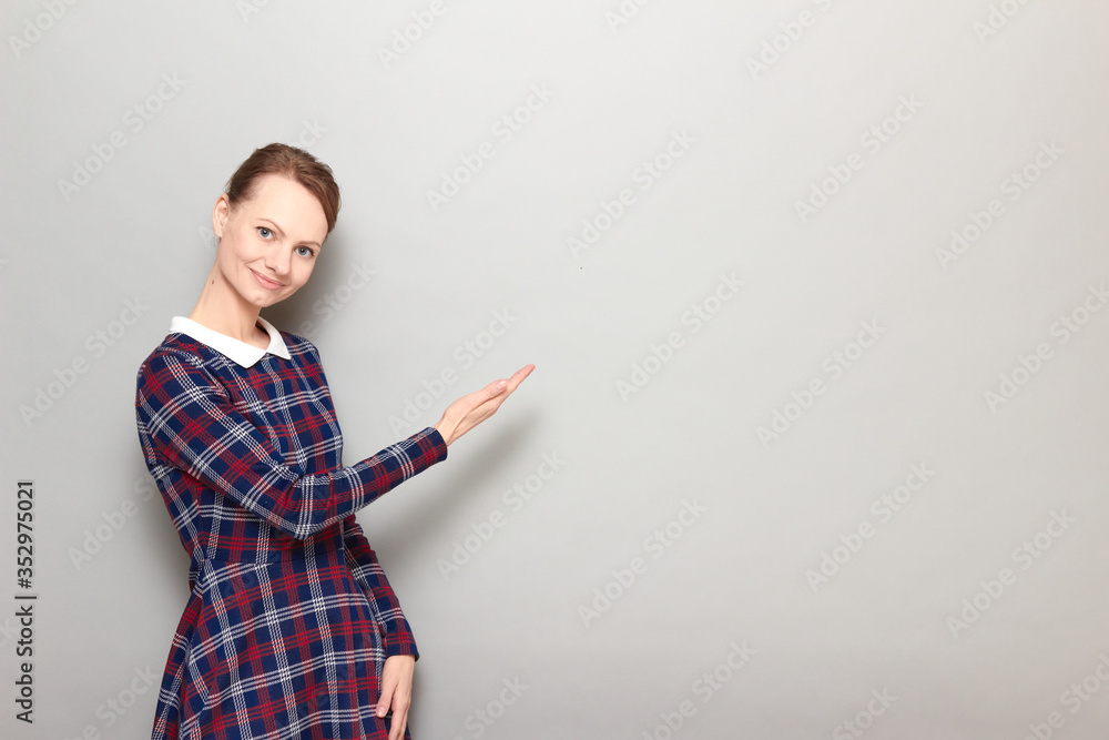 Portrait of pretty cheerful girl pointing with one hand at copy space Portrait of pretty cheerful girl pointing with one hand at copy space