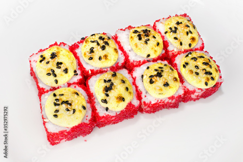 Japanese Yuki roll of rice, shrimp, red tobik, cream cheese, squid, white sauce and sesame seeds on a white plate