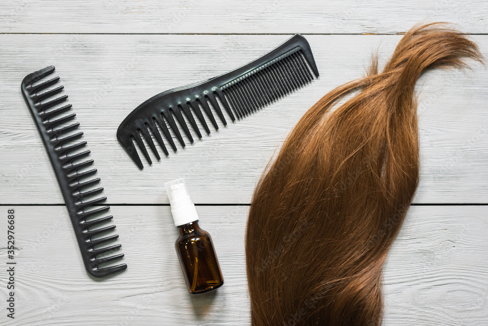 Obraz premium Female hair and a hairbrush on the hairdresser table background.