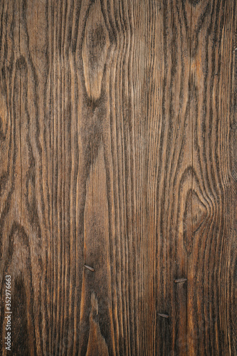 Brown natural organic wood texture with patterns. Background with different shapes, straight and curved lines, on the surface of a wooden board close-up.