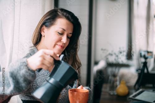 Cuadro en lienzo A woman drinks coffee and works at home.
