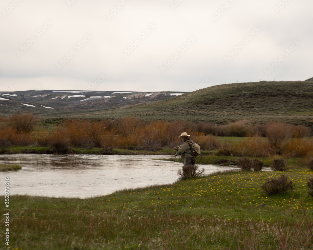 A single man fly fishing in the high country of Wyoming. A single man fly fishing in the high country of Wyoming.