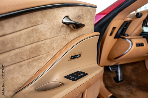 Beige car interior with black buttons on the door. Close-up. Horizontal orientation. photo