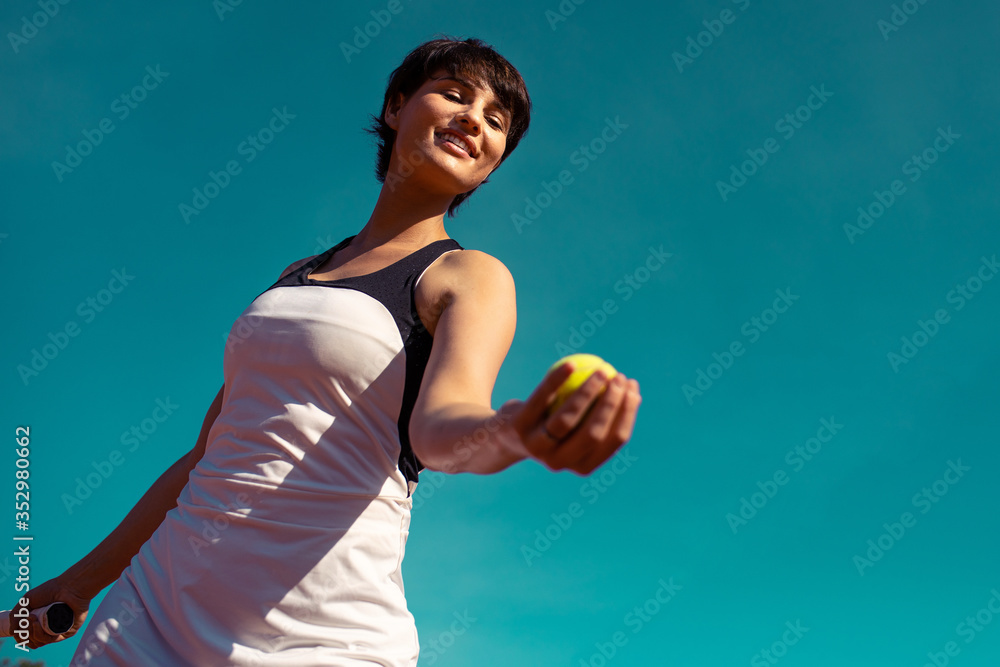 jeune femme lançant une balle de tennis pour faire un service jeune femme lançant une balle de tennis pour faire un service