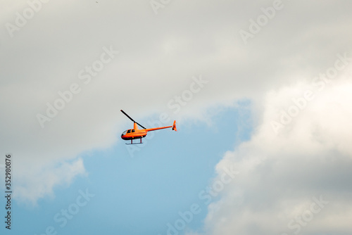 yellow helicopter high in the sky. Horizontal frame