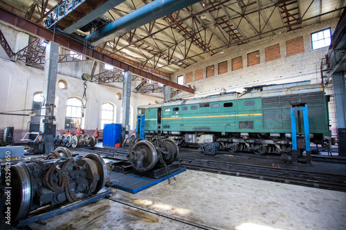 Ussuriysky Locomotive Repair Plant. An old locomotive car is being repaired in a railway depot photo