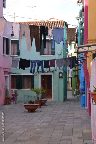 Traditional view of the streets of Burano island. Colorful houses and linen in the courtyards. 