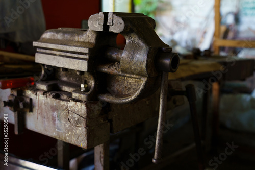 Old rusty steel clamp vise iron metal tool in the workshop workbench in day
